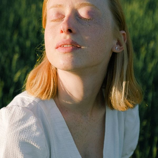 Person meditating peacefully with eyes closed.