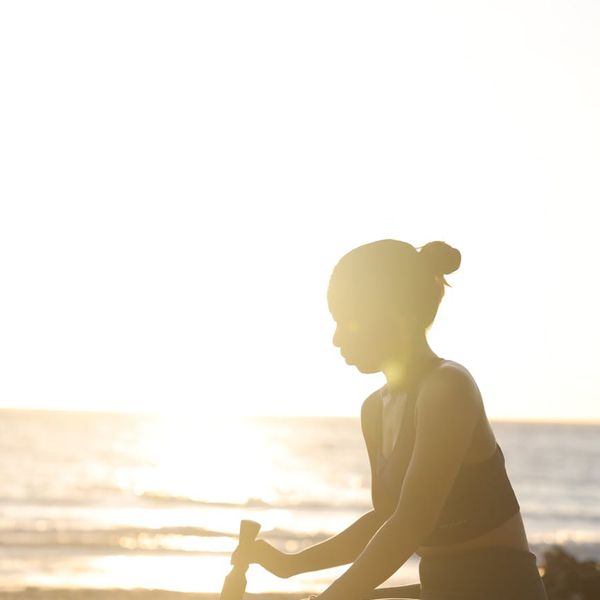 Silhouette of a person in a yoga pose against a sunset.